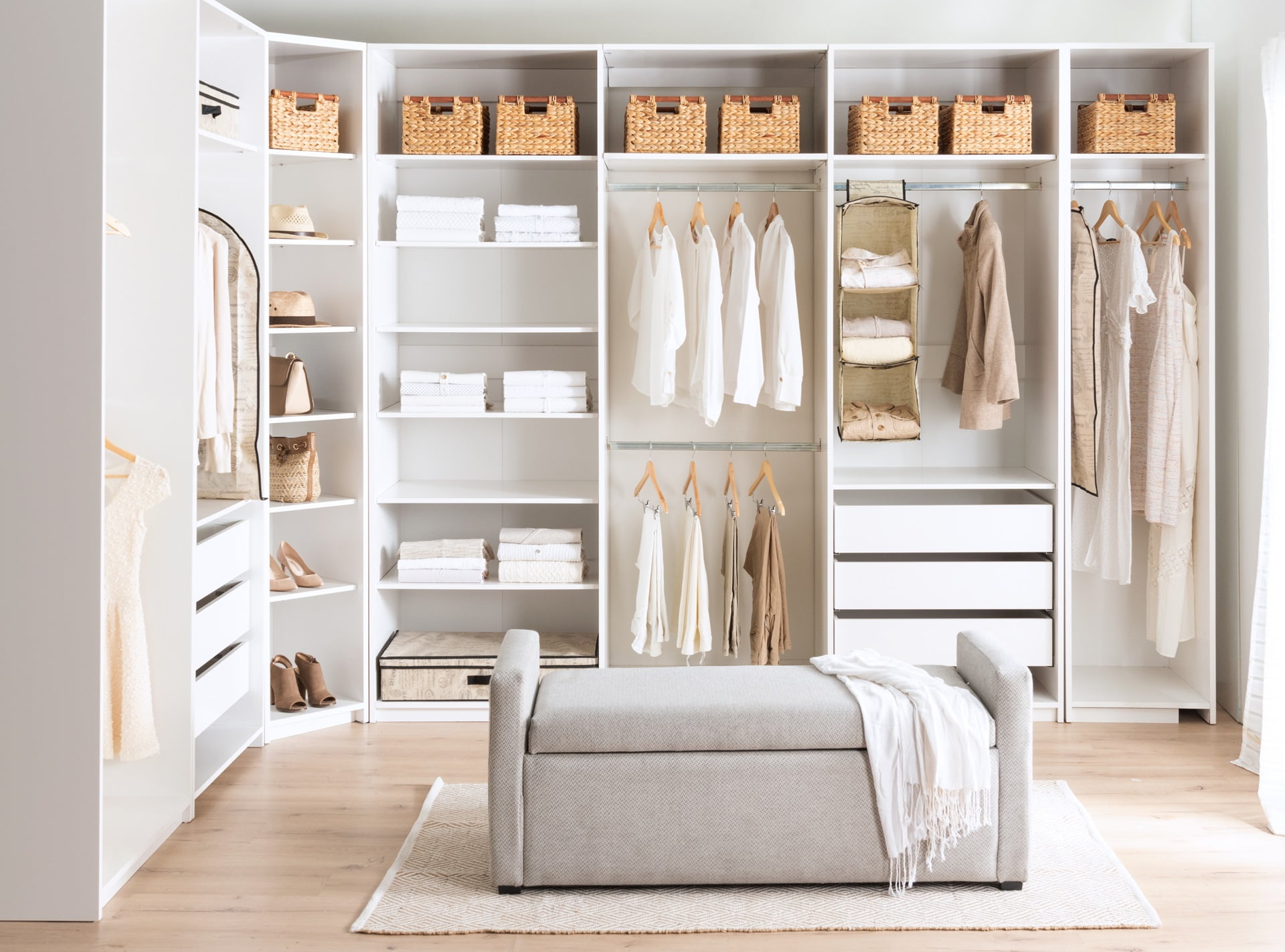 A cozy bedroom with white walls and a closet, featuring clothes hung up in neat fashion - best custom closets sarasota