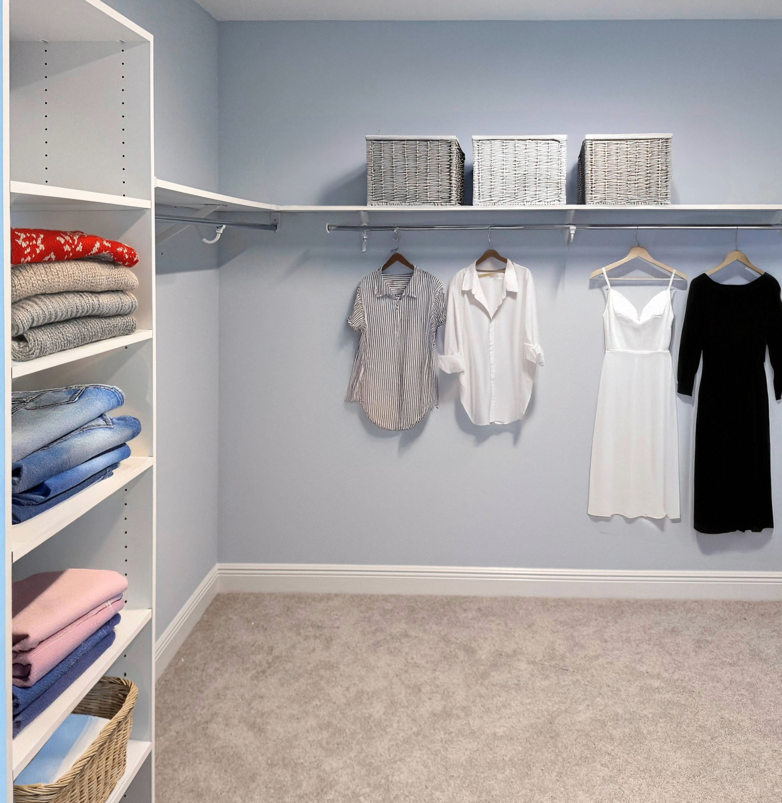 Custom walk-in closet with white shelving, hanging rod, and organized clothing in a Tampa home